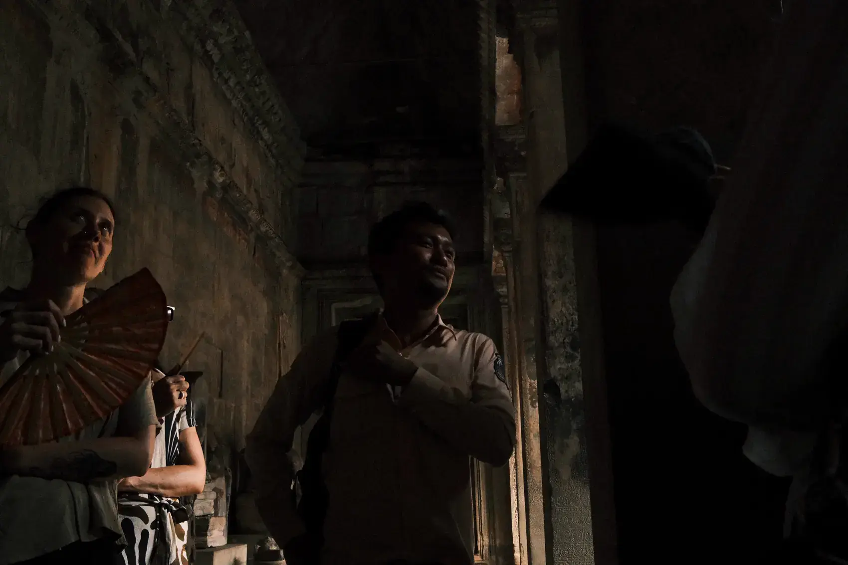 Dos viajeros conversando a contraluz en un pasillo de Angkor Wat