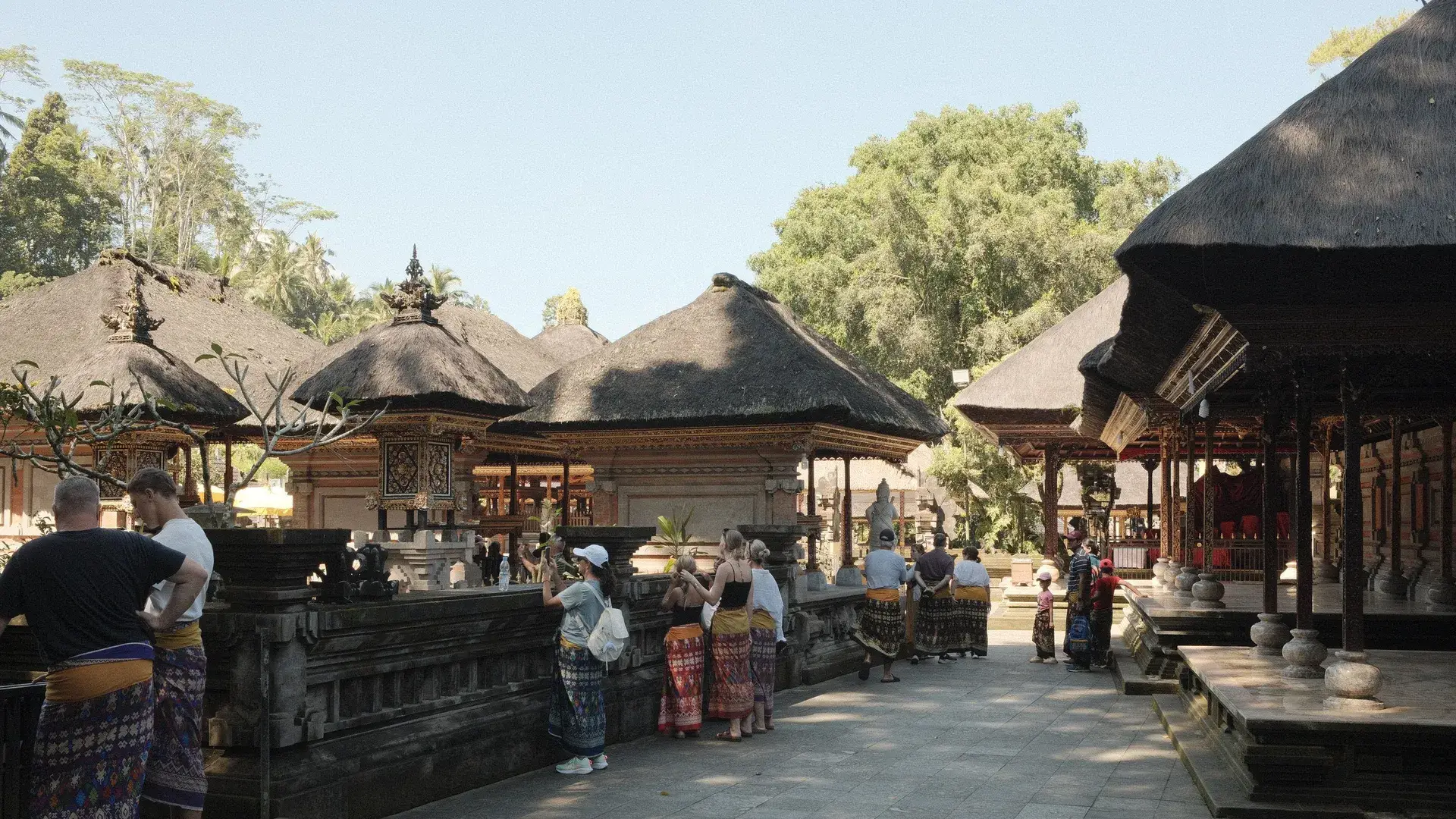 Visitantes en sarong recorriendo un templo de Bali