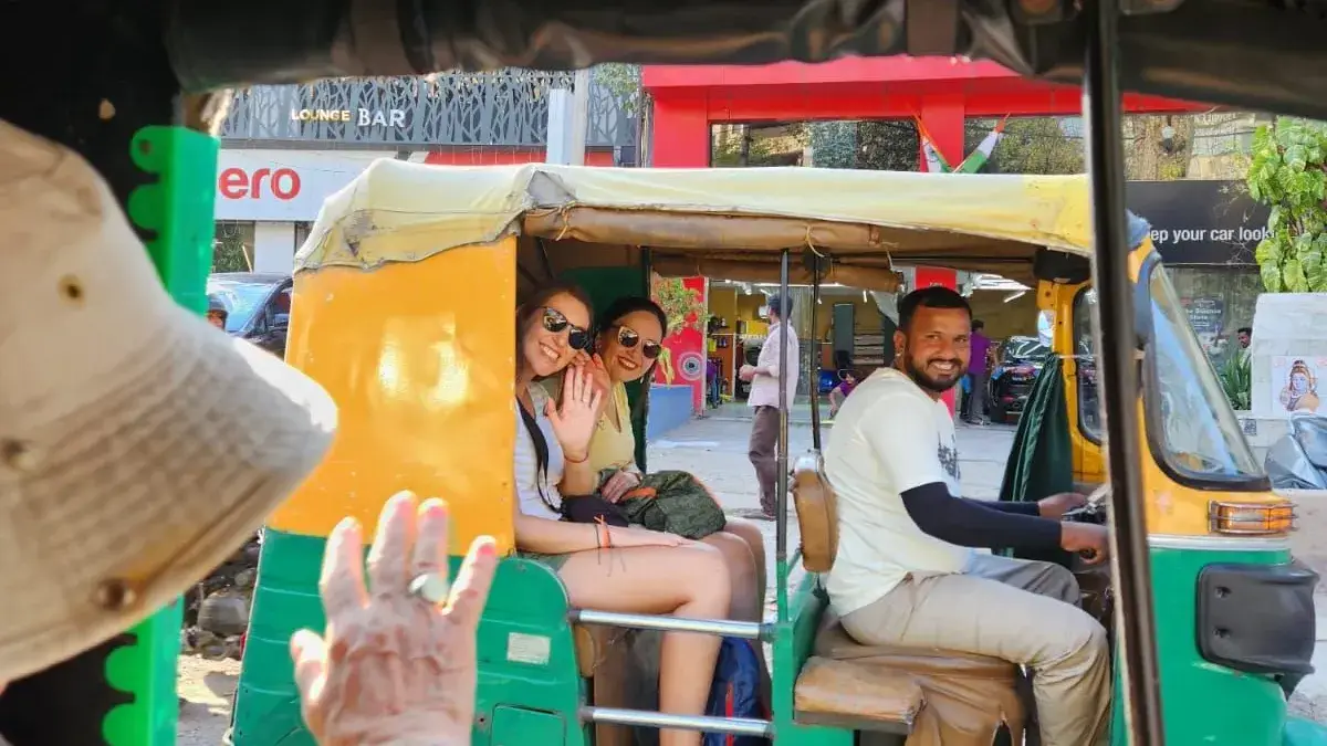 Viajeras saludando desde un tuk-tuk, en la India