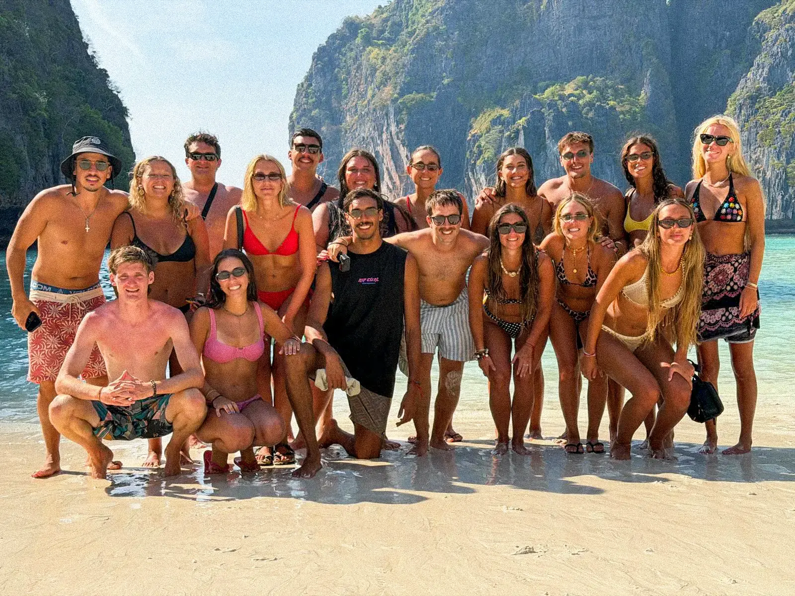 El grupo entero posando en una playa de las islas Phi Phi, con los acantilados de fondo