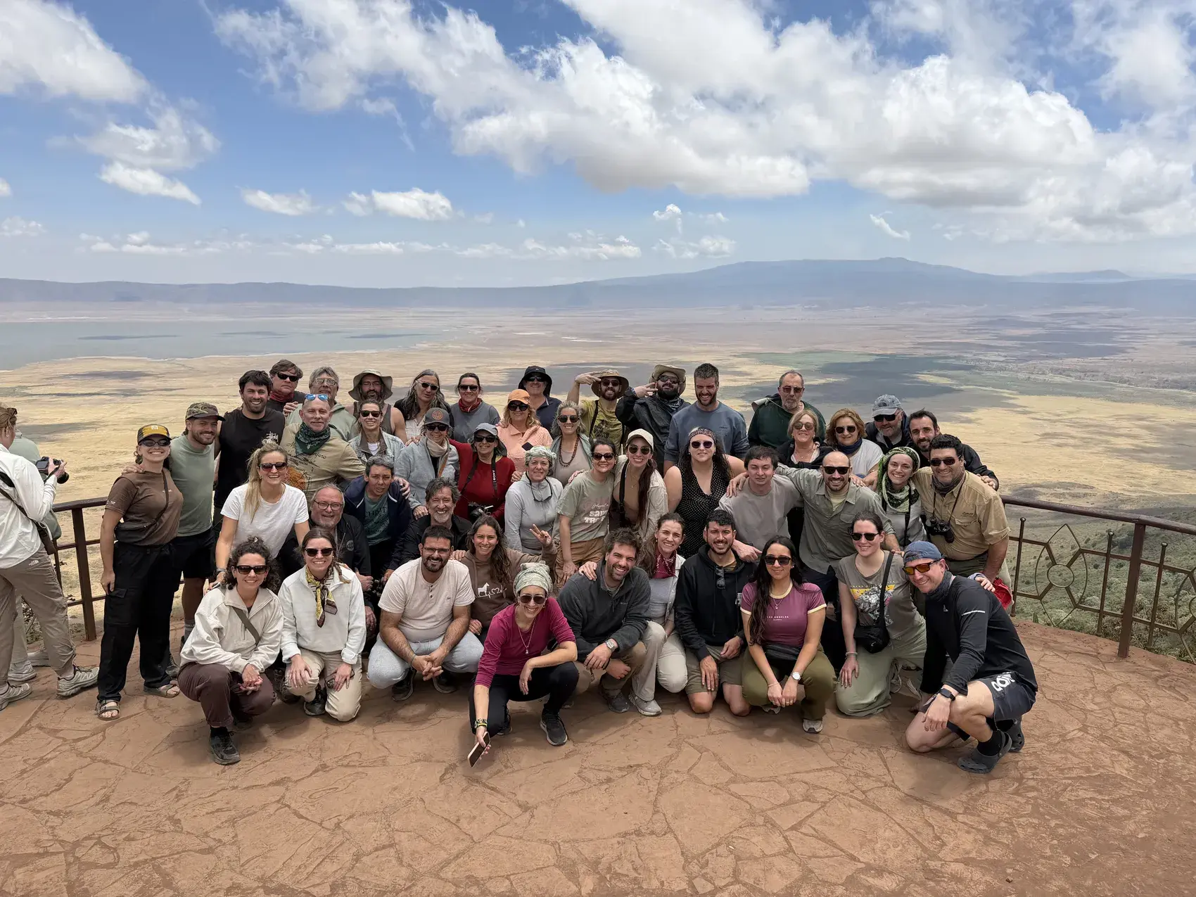 Un grupo grande de viajeros de Toque & Toque posando juntos en un mirador, con una llanura inmensa atrás